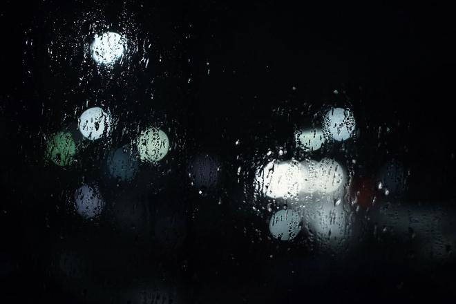 Light shining through raindrops on a window