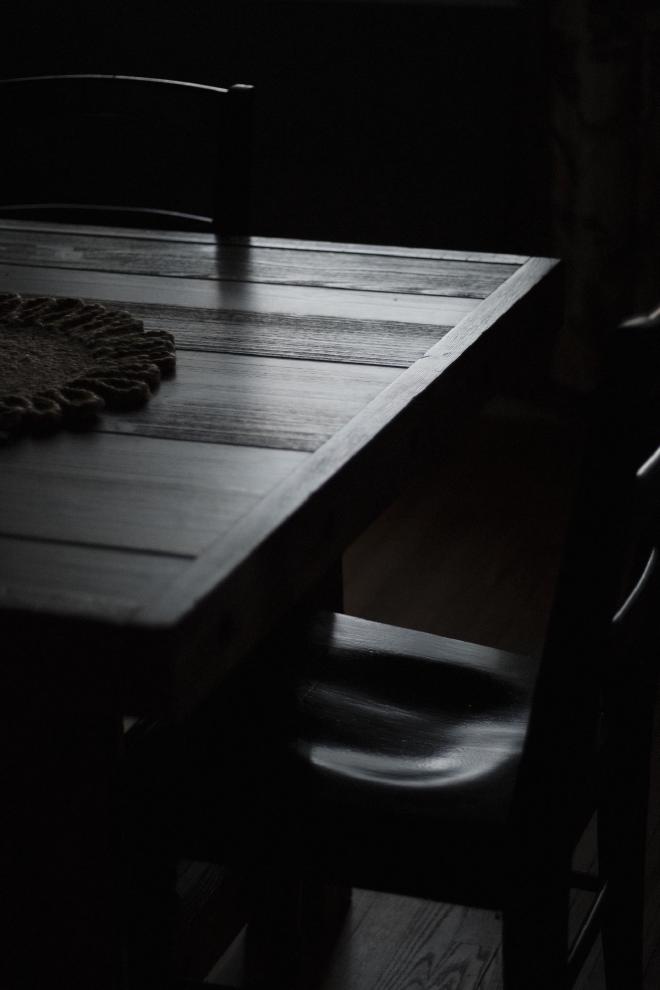 light reflecting on a table and chair in a dark room