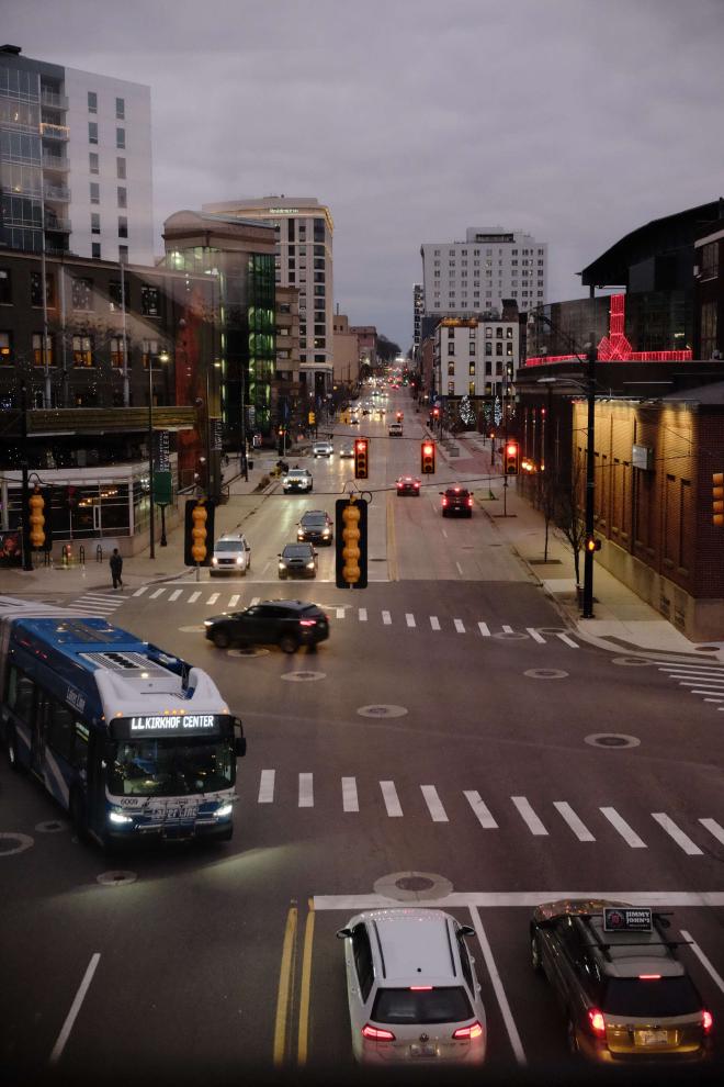 An overlook of a city street with a commuter bus and cars.